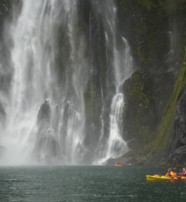  Paddling past waterfalls in Milford Sound New Zealand  